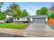 Charming ranch-style house featuring a manicured front lawn, mature trees, and a two-car garage at 4672 S Lewiston Way, Aurora, CO 80015