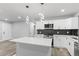 Bright kitchen featuring modern lighting, white cabinetry, and stainless steel appliances at 4672 S Lewiston Way, Aurora, CO 80015