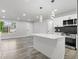 Bright, modern kitchen with quartz island, stainless appliances and stylish lighting at 4672 S Lewiston Way, Aurora, CO 80015