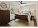 Bedroom with wood bed frame, decorative dresser, ceiling fan, and bright windows for natural light and charm at 1024 S Columbine St, Denver, CO 80209