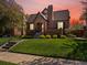Charming brick home featuring an arched entryway and beautifully landscaped front yard at sunset at 1024 S Columbine St, Denver, CO 80209