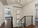 Hallway with black iron railing and three art pieces on the wall with a partial view to a bedroom at 1024 S Columbine St, Denver, CO 80209