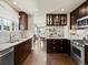 Open kitchen features rich dark wood cabinets, stainless steel appliances, and adjacent living area, perfect for entertaining at 1024 S Columbine St, Denver, CO 80209