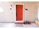 Exterior shot of a red door with white trim, decorative accents, and a welcoming doormat at 4945 Twin Lakes Rd # 44, Boulder, CO 80301