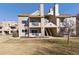 Beige two-story condo building with multiple balconies and well-maintained landscaping under a clear blue sky at 4945 Twin Lakes Rd # 44, Boulder, CO 80301