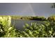 Scenic view of a lake surrounded by lush green trees with a vibrant rainbow arcing across the sky at 4945 Twin Lakes Rd # 44, Boulder, CO 80301