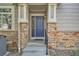 Shot of a charming exterior, front door with stone pillars and a well-manicured front yard at 3546 Broadlands Ln # 102, Broomfield, CO 80023