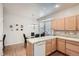 Eat-in kitchen featuring wooden cabinets, tile countertops, and a breakfast nook bathed in natural light from a bay window at 3546 Broadlands Ln # 102, Broomfield, CO 80023