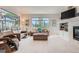 Open living room featuring a cozy fireplace, built-in shelving, and large windows offering serene outdoor views and abundant light at 3546 Broadlands Ln # 102, Broomfield, CO 80023