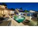 Backyard pool at dusk featuring stone water feature, lounge chairs, and manicured landscaping at 1609 S Clayton St, Denver, CO 80210
