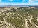 Panoramic aerial view of a wooded community nestled among rolling hills, with a city skyline in the distant background at 997 Dogwood Dr, Golden, CO 80401