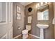Charming powder room boasts natural accents, decorative wall hangings and features modern fixtures at 7329 Arco Iris Ln, Castle Pines, CO 80108