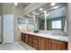 Bathroom with multiple sinks, modern fixtures, ample counter space, and vanity lighting at 7329 Arco Iris Ln, Castle Pines, CO 80108