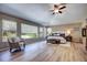 Spacious bedroom with many windows, a ceiling fan, wood floors, and an accent chair at 7329 Arco Iris Ln, Castle Pines, CO 80108