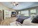 Bright bedroom boasts natural light, wood floors, access to upstairs hallway, and an accent chair at 7329 Arco Iris Ln, Castle Pines, CO 80108
