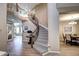 Grand foyer boasts a curved staircase with iron railing and views of the open-concept living and dining areas at 7329 Arco Iris Ln, Castle Pines, CO 80108