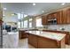 Modern kitchen with island, breakfast bar, stainless appliances and open floor plan at 7329 Arco Iris Ln, Castle Pines, CO 80108
