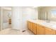 Bathroom with double sinks, tiled floors, and a shower/tub combo at 11729 Elmer Linn Dr, Longmont, CO 80504