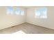 Spacious bedroom with neutral carpeting and multiple windows at 11729 Elmer Linn Dr, Longmont, CO 80504
