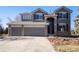 Two-story house with gray siding, stone accents, and a two-car garage at 11729 Elmer Linn Dr, Longmont, CO 80504