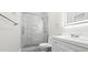 Bright bathroom featuring white vanity, toilet, and glass enclosed shower with marble tiling at 8250 W 63Rd Ave, Arvada, CO 80004
