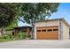 Beautiful home featuring a modern garage door, stone accents, and manicured front yard at 8250 W 63Rd Ave, Arvada, CO 80004