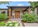 Inviting front entry with a covered porch, attractive double doors, and professionally landscaped garden at 8250 W 63Rd Ave, Arvada, CO 80004