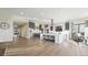 Bright open-plan living area connecting the kitchen and living space, with hardwood flooring throughout at 8250 W 63Rd Ave, Arvada, CO 80004