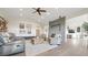 Open living room featuring a ceiling fan, fireplace, and hardwood flooring at 8250 W 63Rd Ave, Arvada, CO 80004