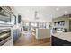 Open concept living space connecting kitchen and fireplace, featuring hardwood floors and recessed lighting at 8250 W 63Rd Ave, Arvada, CO 80004