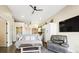 Comfortable living room featuring a sofa, armchair, TV, and an open layout with a view of the kitchen at 8250 W 63Rd Ave, Arvada, CO 80004