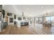 Large open living space featuring the living, kitchen, and dining areas with hardwood floors and ample sunlight at 8250 W 63Rd Ave, Arvada, CO 80004