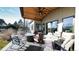 Covered outdoor patio area featuring lots of seating, outdoor fireplace, and retractable shades at 8250 W 63Rd Ave, Arvada, CO 80004