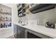 Modern wet bar featuring custom shelving, a sink, and a beverage refrigerator for entertaining at 8250 W 63Rd Ave, Arvada, CO 80004