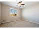 Bright bedroom featuring neutral carpeting, a large window, and a ceiling fan at 9462 Yampa Ct, Commerce City, CO 80022