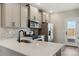 Bright kitchen showcasing quartz countertops, stainless steel appliances, and grey cabinetry at 9462 Yampa Ct, Commerce City, CO 80022