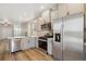 Modern kitchen with stainless steel appliances, granite countertops, and wood flooring at 9462 Yampa Ct, Commerce City, CO 80022