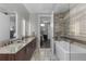 Bright bathroom with dual sinks, granite countertops, and a separate tub at 4200 W 17Th Ave # 912, Denver, CO 80204
