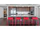 Modern kitchen featuring stainless steel appliances, granite countertops, a spacious island and stylish red bar stools at 4200 W 17Th Ave # 912, Denver, CO 80204