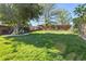 Sprawling backyard with a large manicured lawn, mature shade trees, garden beds, and privacy fence at 760 Deframe St, Golden, CO 80401