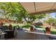 Charming backyard with a retractable awning, a stone garden, and mature trees offering shaded outdoor living space at 760 Deframe St, Golden, CO 80401