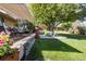 Spacious backyard with mature trees, large patio with dining and lounge area, and lush landscaping at 760 Deframe St, Golden, CO 80401