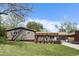 Charming home featuring a well-manicured lawn, mature trees and a welcoming front entrance with a pergola and flower boxes at 760 Deframe St, Golden, CO 80401