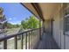 Relaxing balcony showcasing wooden floors and railing, providing serene outdoor living with a pleasant view at 8780 E Yale Ave, Denver, CO 80231