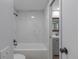 Updated bathroom featuring white marble tile surround on tub and shower at 8780 E Yale Ave, Denver, CO 80231