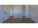 Carpeted bedroom featuring an open closet and white walls at 8780 E Yale Ave, Denver, CO 80231