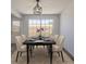Bright dining room with a large window, modern light fixture, and table set for six at 8780 E Yale Ave, Denver, CO 80231