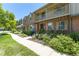 Charming townhome with brick and neutral siding, complimented by a balcony and mature landscaping at 8780 E Yale Ave, Denver, CO 80231