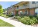 Lovely townhome featuring a brick facade, a second-story balcony, and well-maintained greenery at 8780 E Yale Ave, Denver, CO 80231