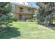 Beautiful townhome featuring a classic brick facade, a welcoming balcony, and a well-manicured lawn at 8780 E Yale Ave, Denver, CO 80231